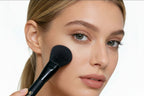 A woman is using a Sophienia powder brush.