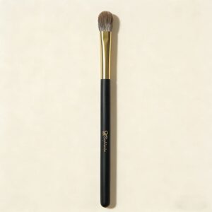 Sophienia eyeshadow blending brush with soft gray bristles, gold ferrule, and black handle on cream background