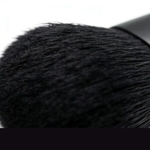 Soft black makeup powder brush with dense bristles shown in close-up macro detail against white background