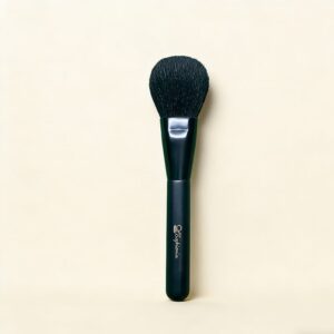 Black Sophienia makeup powder brush with soft rounded bristles and matte handle on cream background
